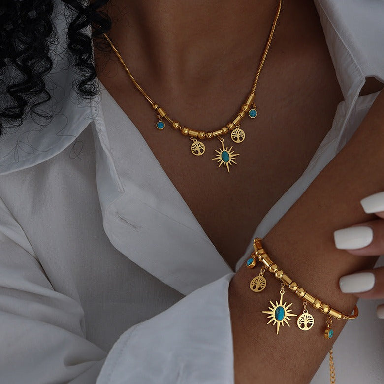 Gold and Blue stone necklace featuring a star and trees on a model with matching bracelet